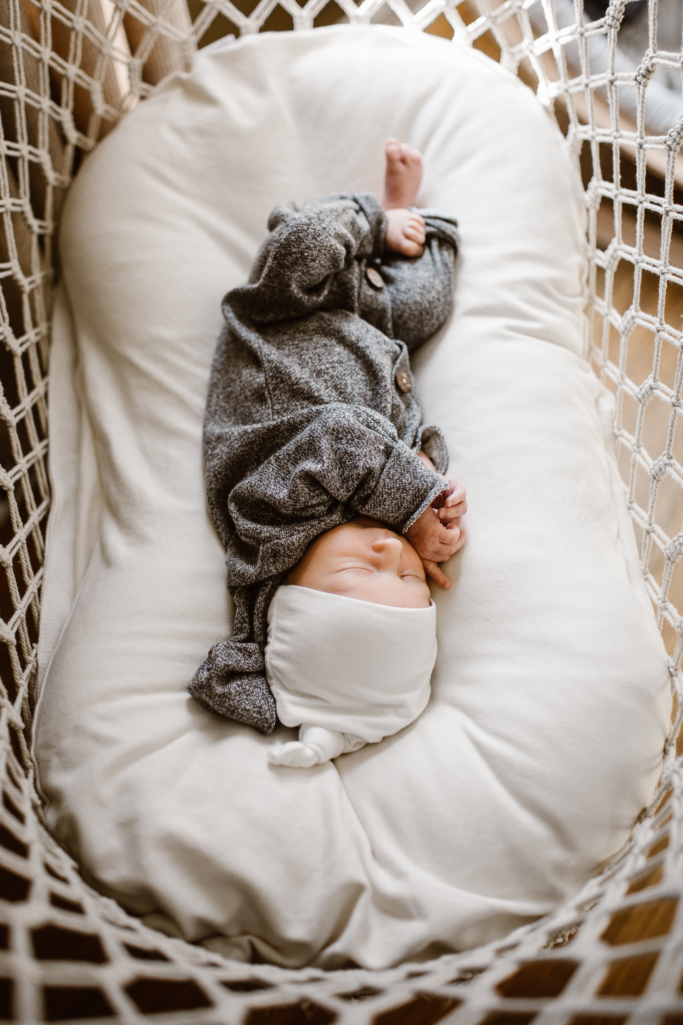 Newborn baby boy cozy in his bassinet.